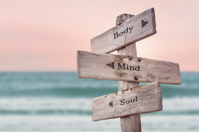 body mind soul text quote written on wooden signpost by the sea. Positive pink turqoise pastel theme. body mind soul text quote written on wooden signpost by the sea. Positive pink turqoise pastel theme.